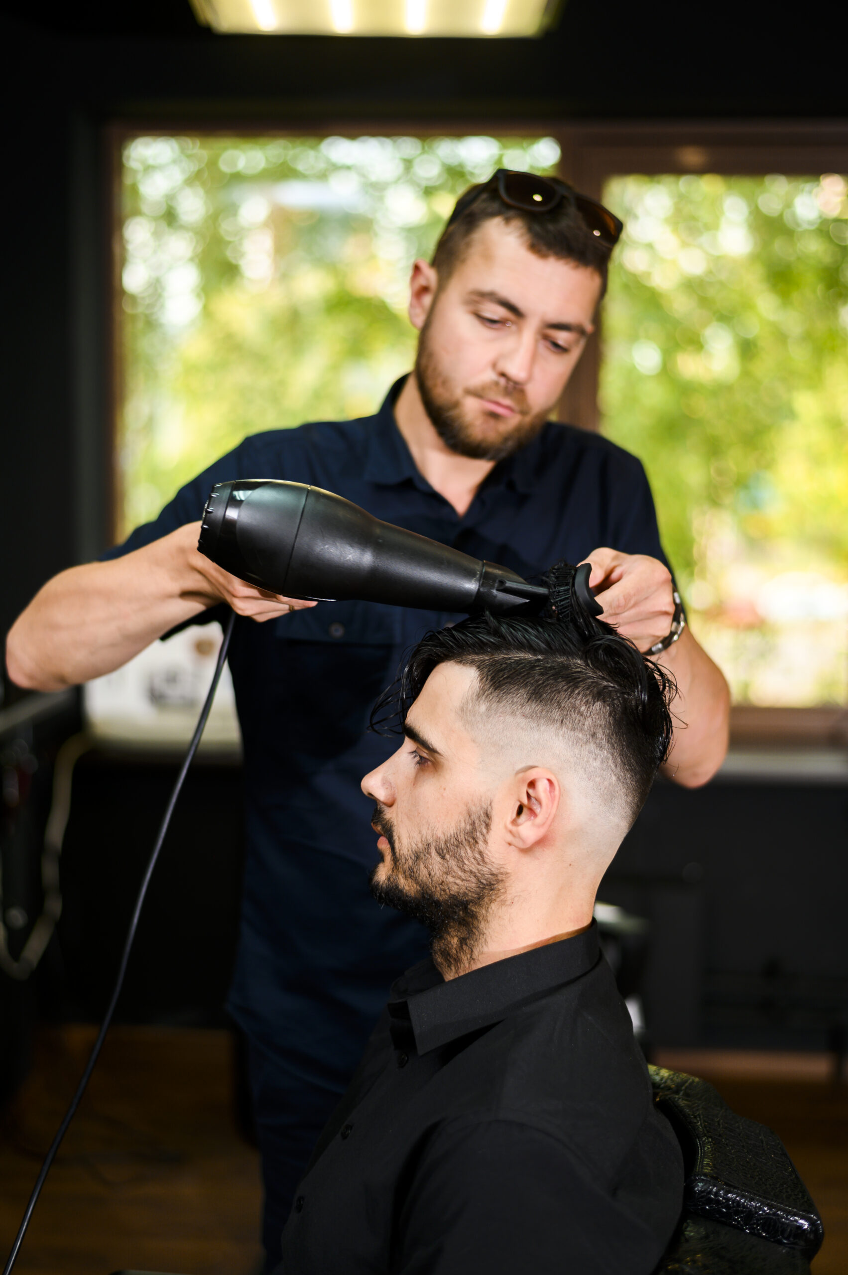 hair-stylist-drying-his-client-s-hair